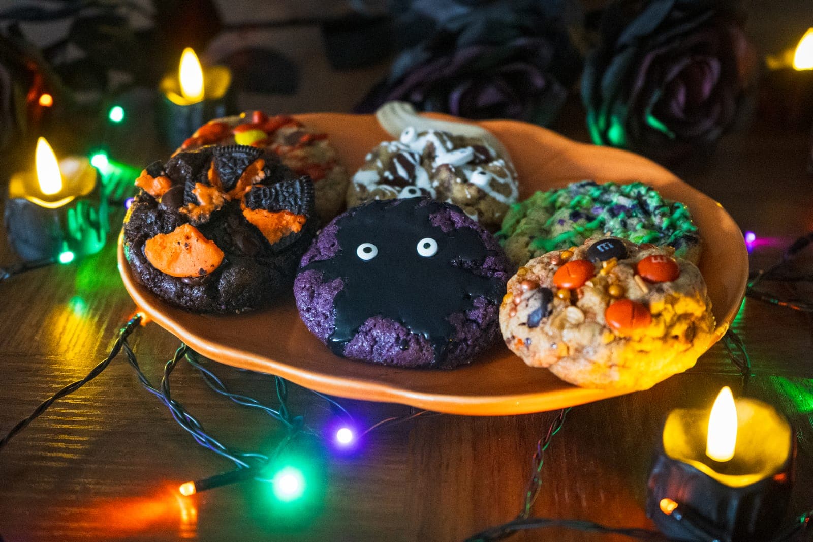 Plate of Halloween cookies: Oreo Brownie, Ube Monster, Fall M&M, Slimy Sugar, Spooky Chocolate Chip and Bloody Reese’s