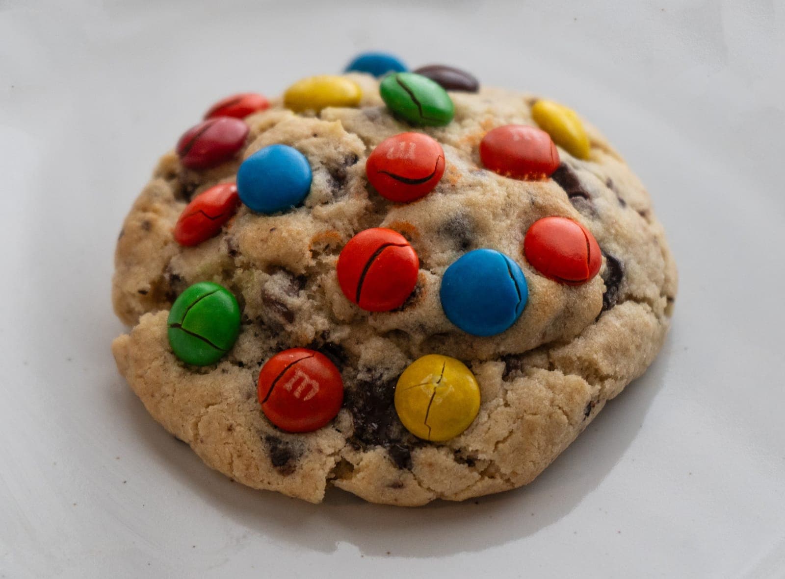 Large M&M cookie on a white plate