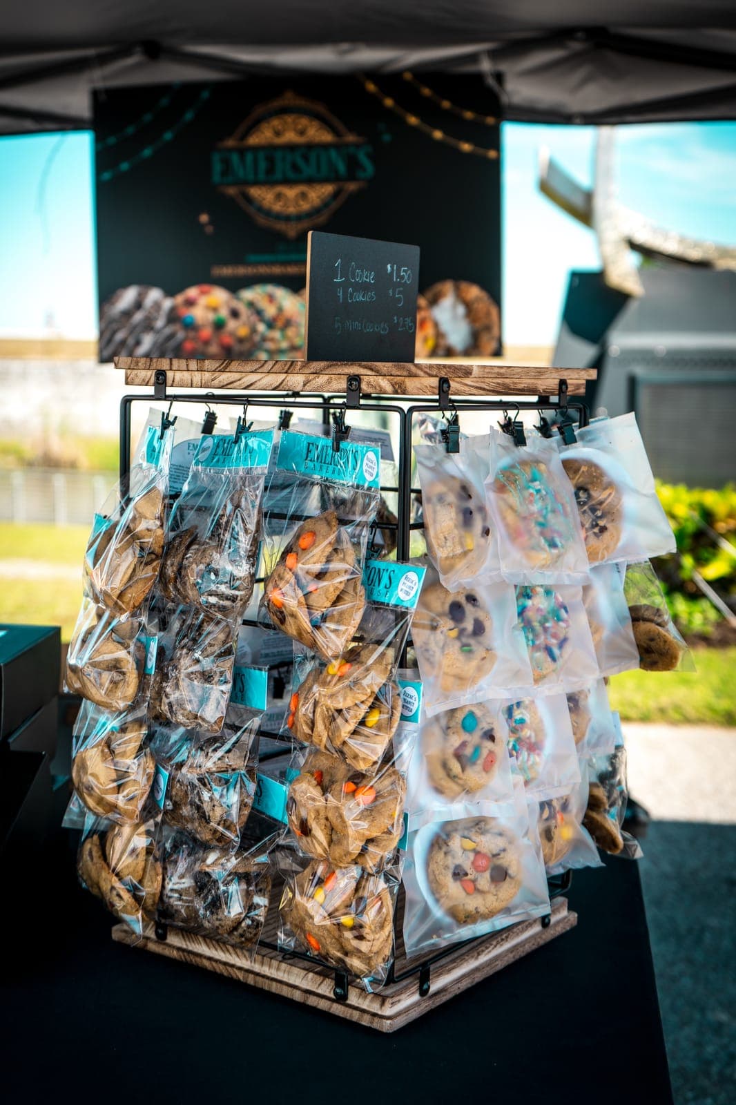 Rack of bagged Emerson's Bakehouse cookies in front of the bakehouse banner
