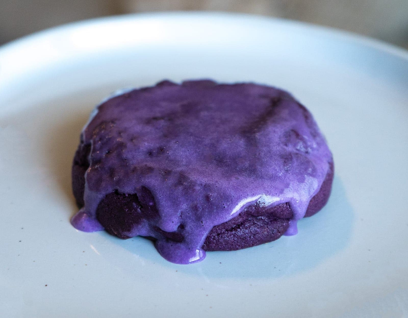 Purple Ube cookie with purple ube drizzle on a plate