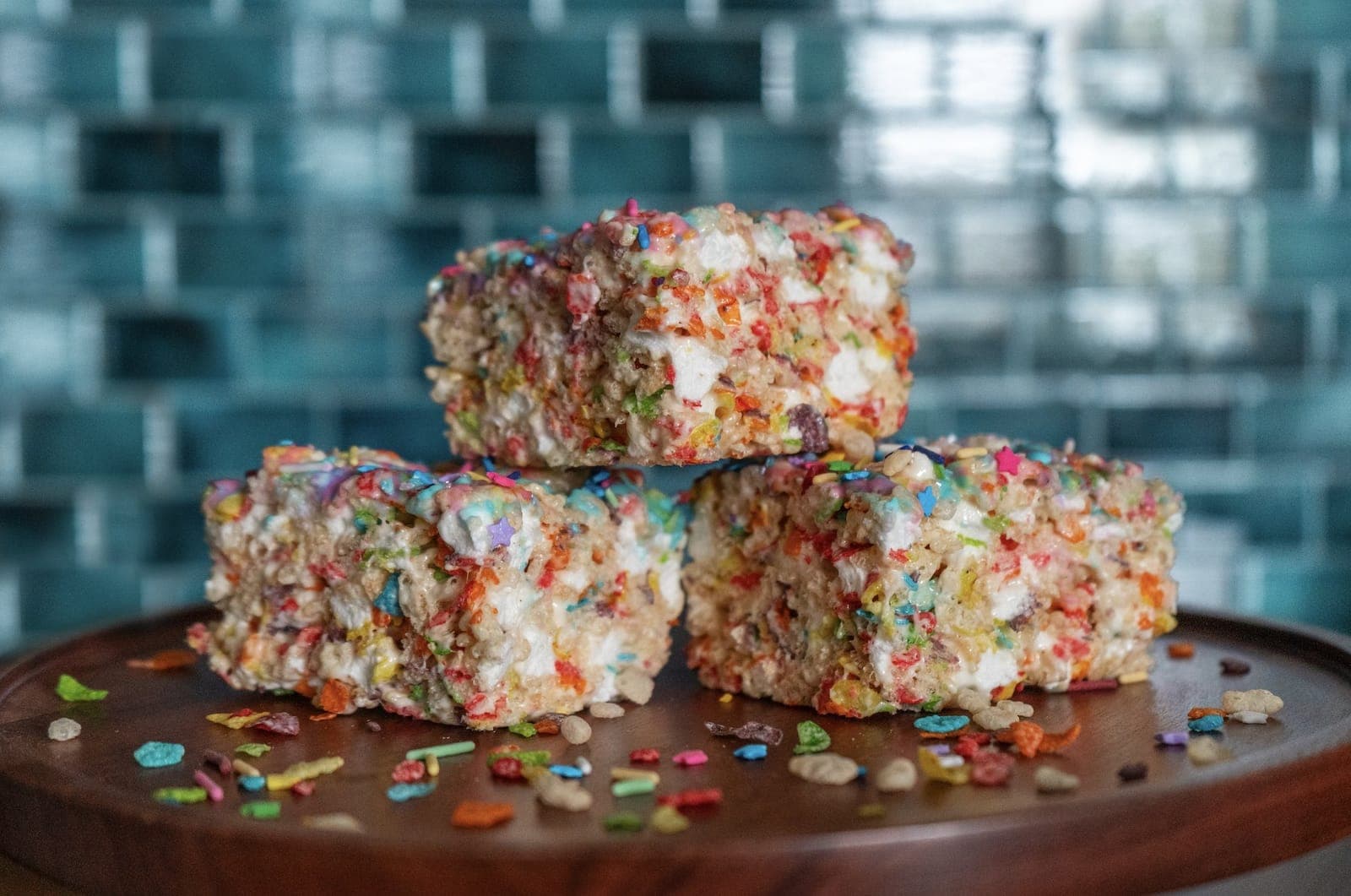 Unicorn Crispies made with Fruity Pebbles stacked on a wooden board